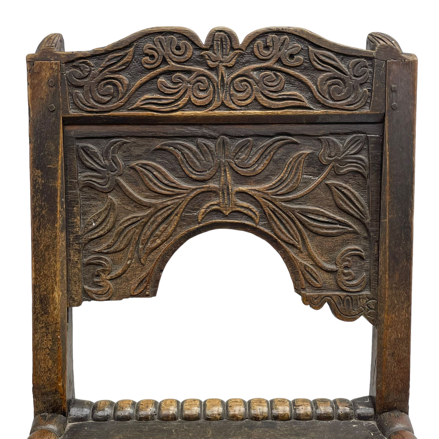 Set of three 18th century carved oak back stools, the cresting rail carved with scrolling foliate motifs over an arched panel with a stylised tree carving with extending leafage, the panelled seat held within a bobbin-turned frame, raised on turned supports united by a ring-turned front stretcher