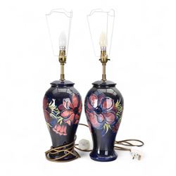 Pair of Moorcroft table lamps, in Anemone patter, upon a blue ground, with cream lampshades, H68