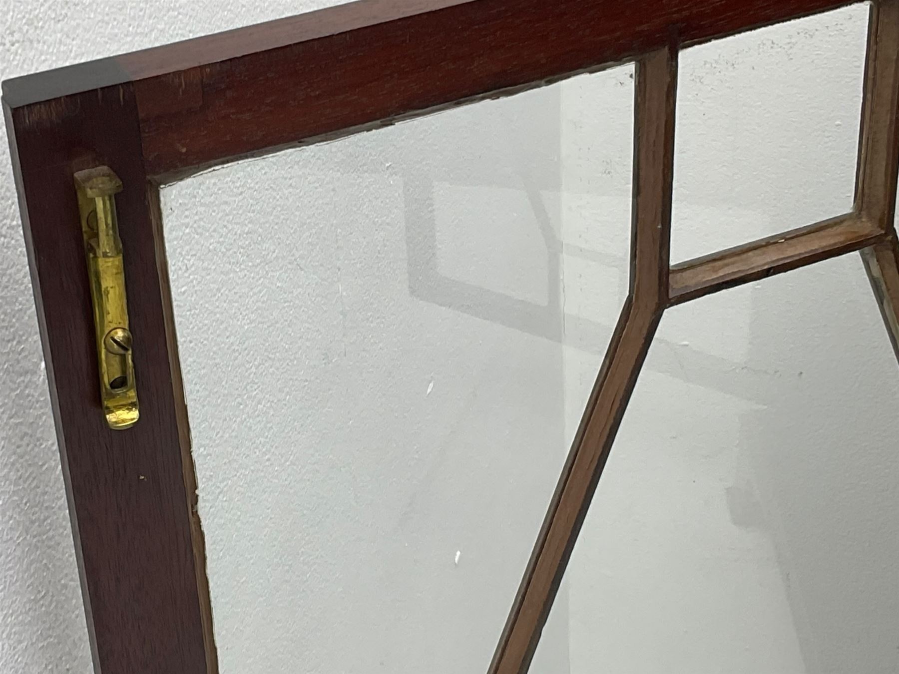 Early 20th century mahogany bookcase, projecting dentil cornice over blind fretwork frieze, enclosed by two astragal glazed doors, on shaped bracket feet 