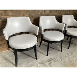 Four ebonised framed tub shaped armchairs, upholstered in grey fabric