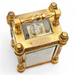 French - Edwardian 8-day timepiece carriage clock in a brass case with glazed side and rear door panels, brass foliate embellished dial mask with a circular enamel dial, Roman numerals and retailers name (indistinct), minute track and steel hands, with a cylinder platform escapement, wound and set from the rear.  