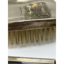 A pair of silver mounted clothes brushes, each with engine turned detail and monogramed central panel, and silver comb mount, all hallmarked Adie Brothers Ltd, Birmingham, date letters worn and indistinct, together with a cased set of six mother of pearl knives with silver ferrules, hallmarked William Yates Ltd, Sheffield 1916, a silver plated bottle coaster, with pierced sleeve and twin handles, marked beneath for Daniel and Arter, Birmingham, and a set of six silver plated coffee bean spoons. 