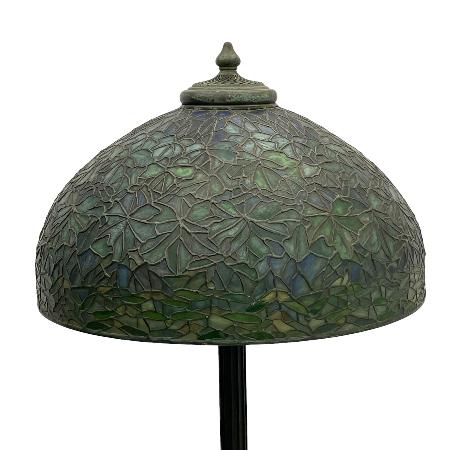 In the manner of Tiffany & Co. - bronze 'Chased Pod' design floor lamp, 'Maple Leaf' dome leaded glass shade decorated with flowers in blue and green shades, six branches on column decorated with stylised trailing stems terminating to circular base with stylised plant decoration, on scrolled feet, the base stamped 'Tiffany Studios New York 379' the inner shade stamped 'Tiffany Studios New York [...]'