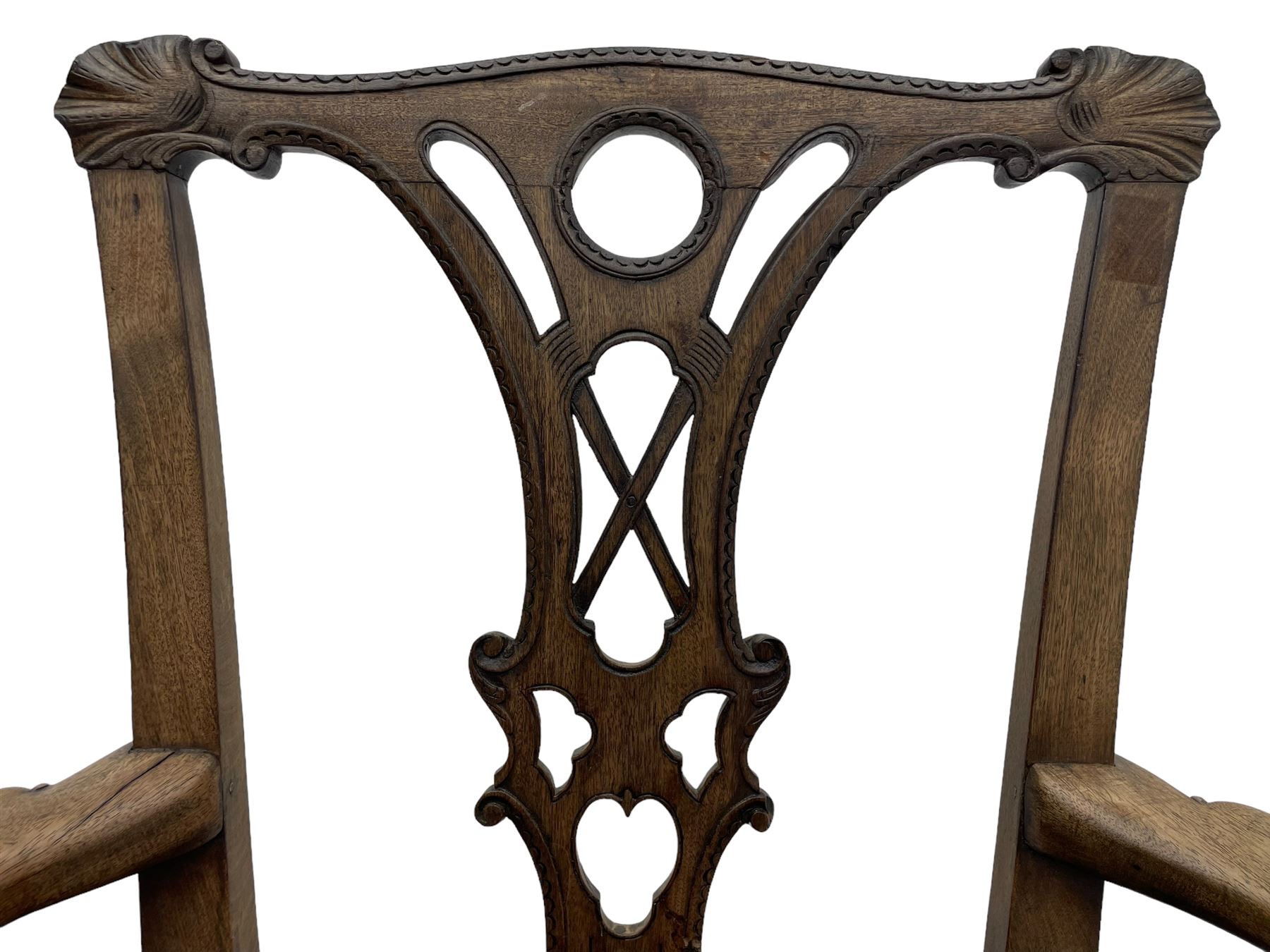 Unusual 18th century mahogany elbow chair, the shaped cresting rail with projecting shell carved ears, pierced and scroll carved splat over drop-in upholstered seat, shaped arms with ball and claw carved terminals, the seat rails carved with shell cartouches, on foliate carved cabriole supports with ball and claw feet 