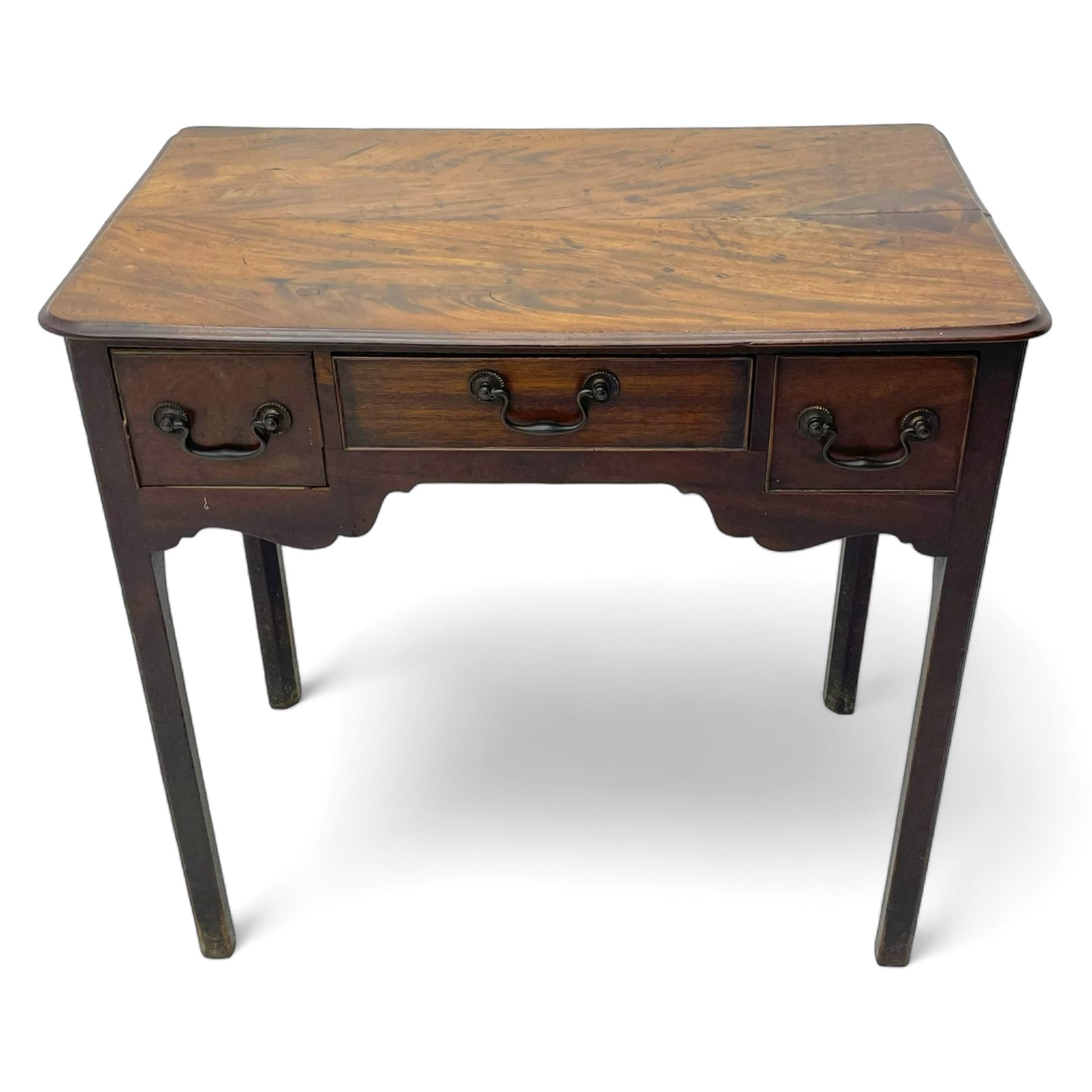 George III mahogany low-boy, moulded rectangular top with rounded front corners, fitted with three cock-beaded drawers, beaded circular brass handle plates and swan neck handles, shaped apron, on square supports with inner chamfer 