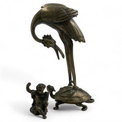 Early 20th century Japanese bronze figure or Okimono, modelled as a crane standing atop a turtle shell, possibly a candle holder, H25cm together with a small bronze figure modelled as a seated Cherub, H7cm (2)