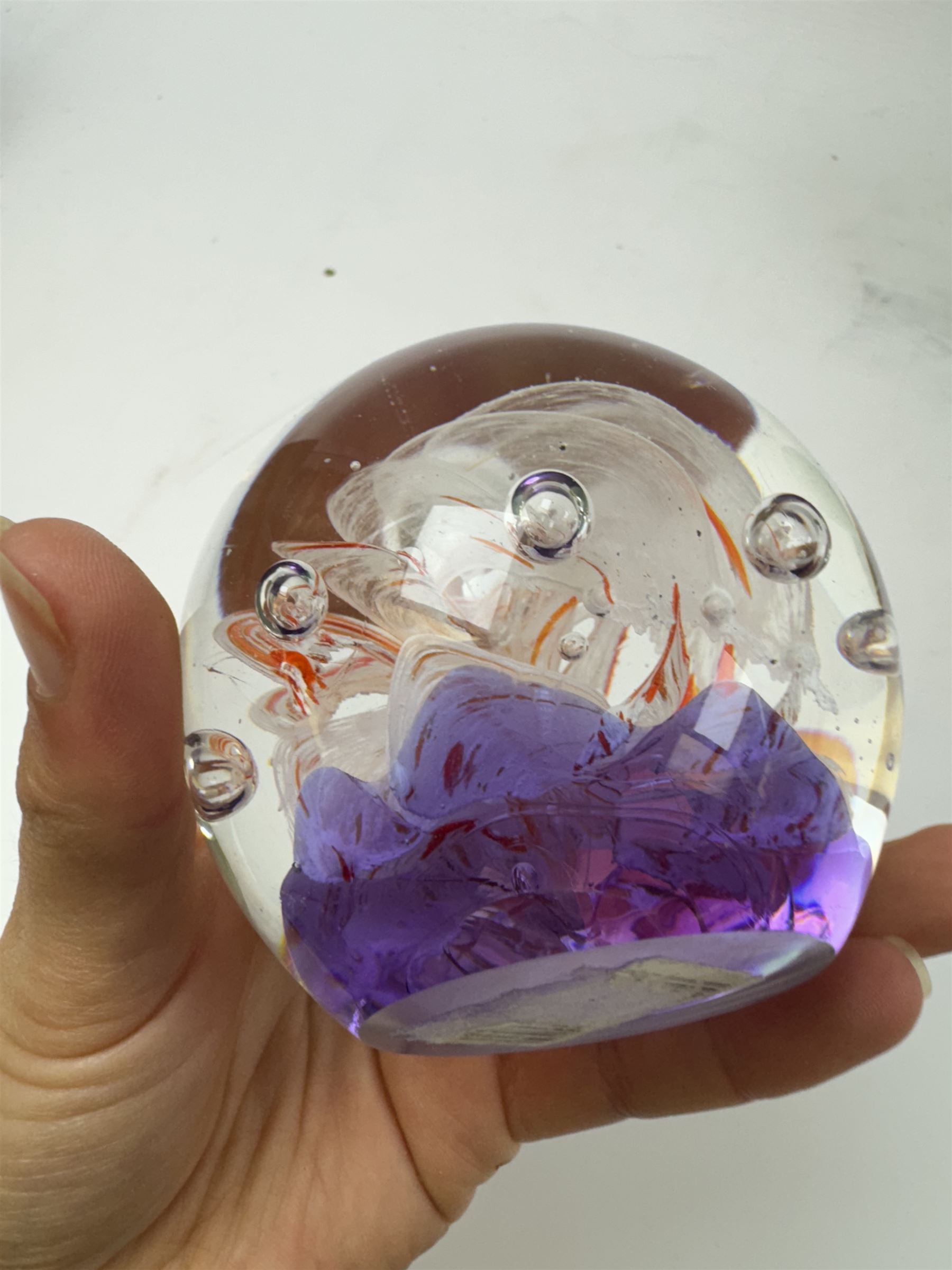 Two glass dump paperweights, with flower inclusions, together with four further glass paperweights