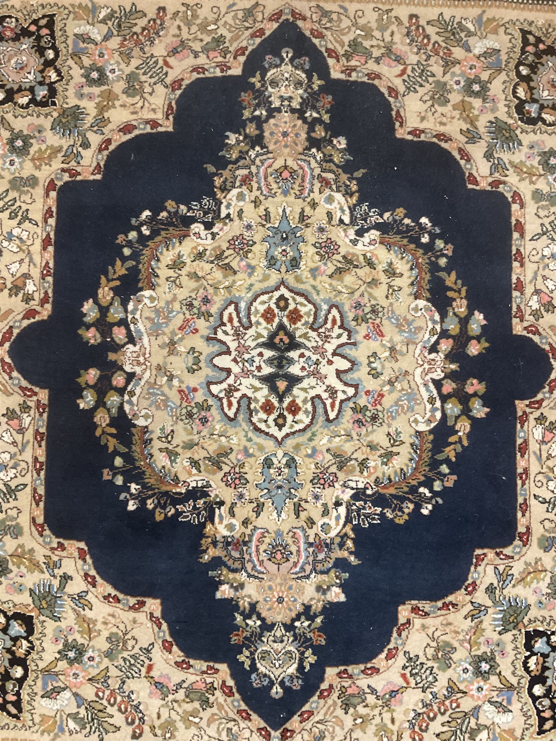 Persian Kirman indigo ground rug, central floral design medallion with matching spandrels, the guarded border decorated with stylised plant motifs 