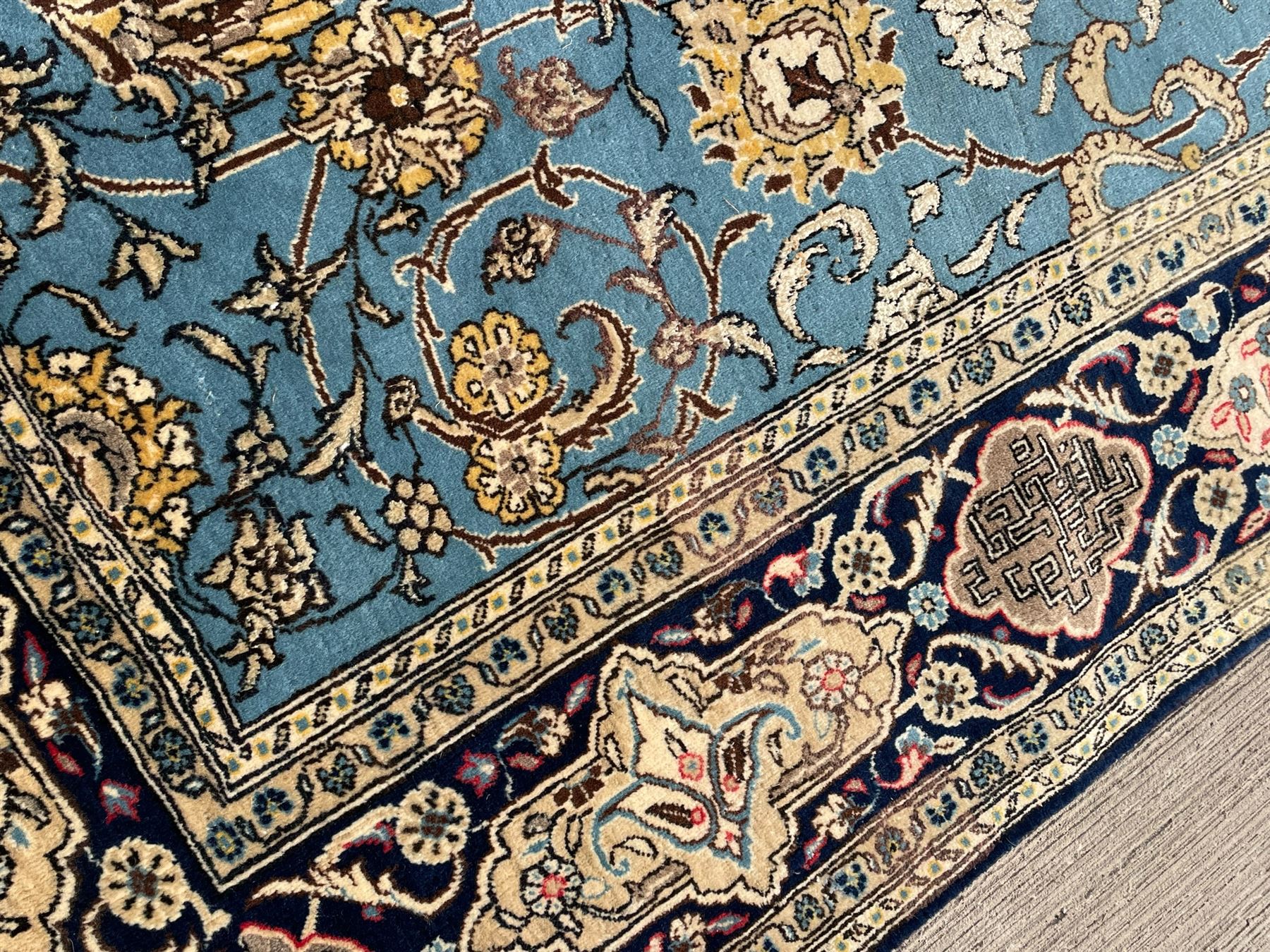 Persian Nain blue ground rug, overall arabesque design, the busy field decorated with interlacing branches and palmettes, indigo ground border with panels decorated with knots and lotus flower motifs, surrounded by trailing branches and flower heads, within guard stripes