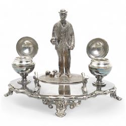 Victorian silver-plated inkstand by James Dixon & Sons, the quatrefoil base surmounted with a figure of a lawn bowler stood upon an oval grass base, with three lawn bowls by his feet, the inkwells formed as two bowls, each with hinged covers and silver-plated liners, bamboo moulded pen rest and gallery, supported by four pierced and splayed feet, L22cm x H17cm