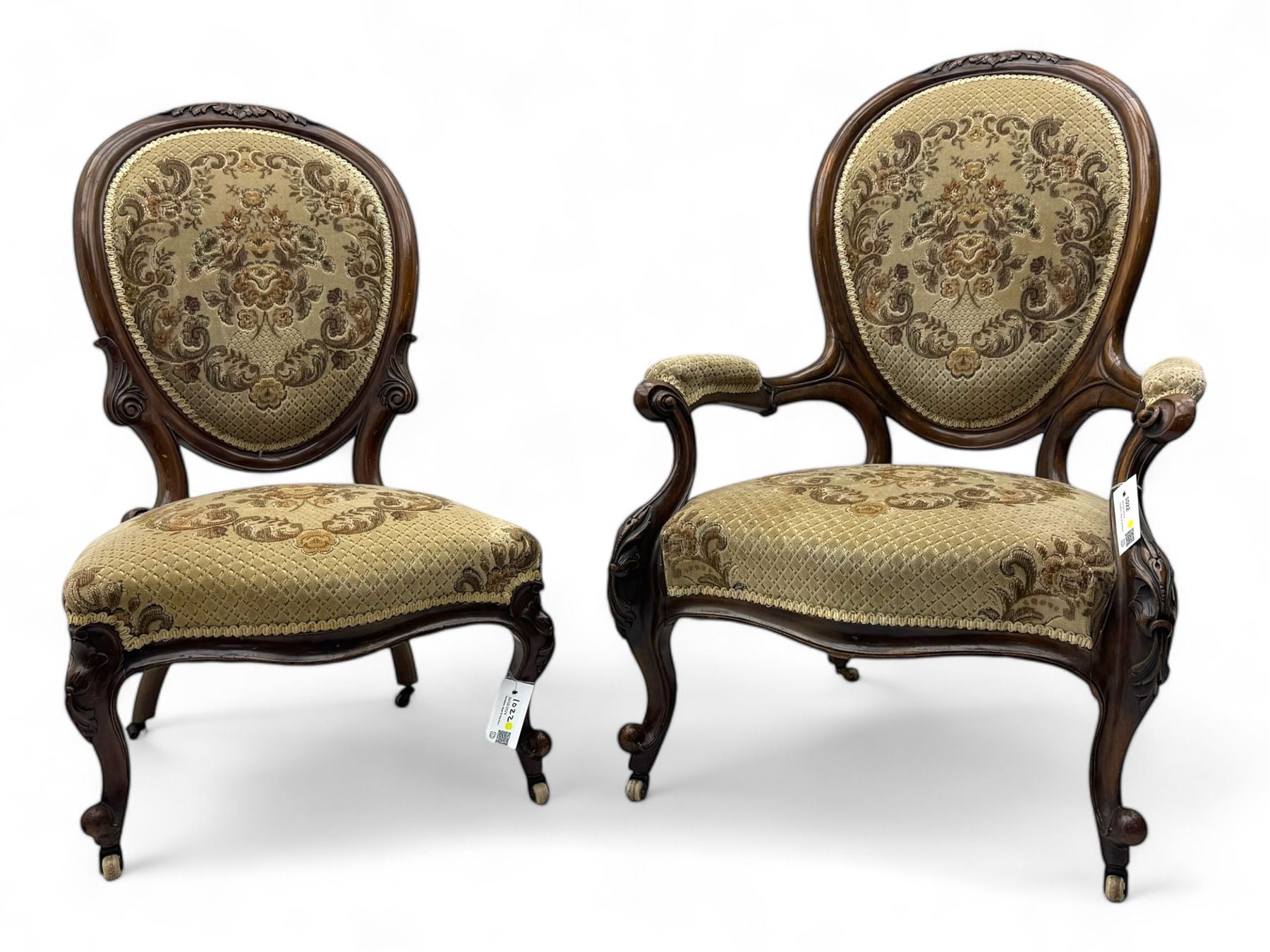 Pair of Victorian walnut lady's and gentleman's drawing room chairs, arched cresting rail carved with cartouche and extending foliage, upholstered in floral pattern fabric, on foliate carved cabriole feet