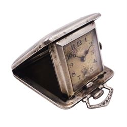 Continental silver travelling clock, of square form contained within engine turned case with engraved cartouche and sprung hinged cover, the white dial with enamelled numbers and marked 'Swiss Made', with import marks for C E Ltd, London 1935, L3.5cm
