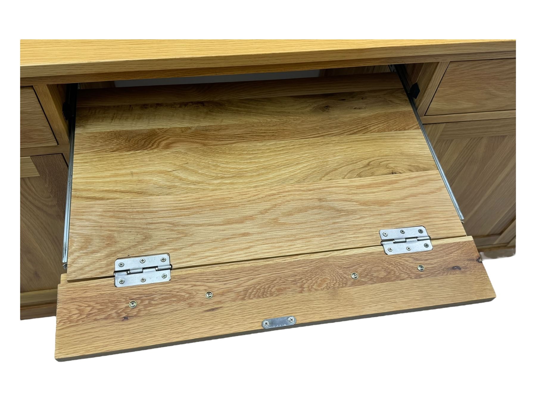 Contemporary light oak twin pedestal desk, fitted with three drawers over two cupboards with chrome handles, the central drawer with hinged front panel revealing pull-out keyboard tray, on plinth base