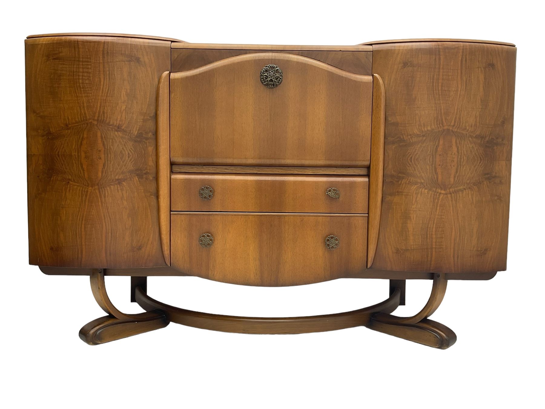 Beautility - mid-20th century walnut sideboard, fall-front with sliding top enclosing mirror interior, fitted with two drawers and flanking cupboards, on sledge feet with curved stretchers 