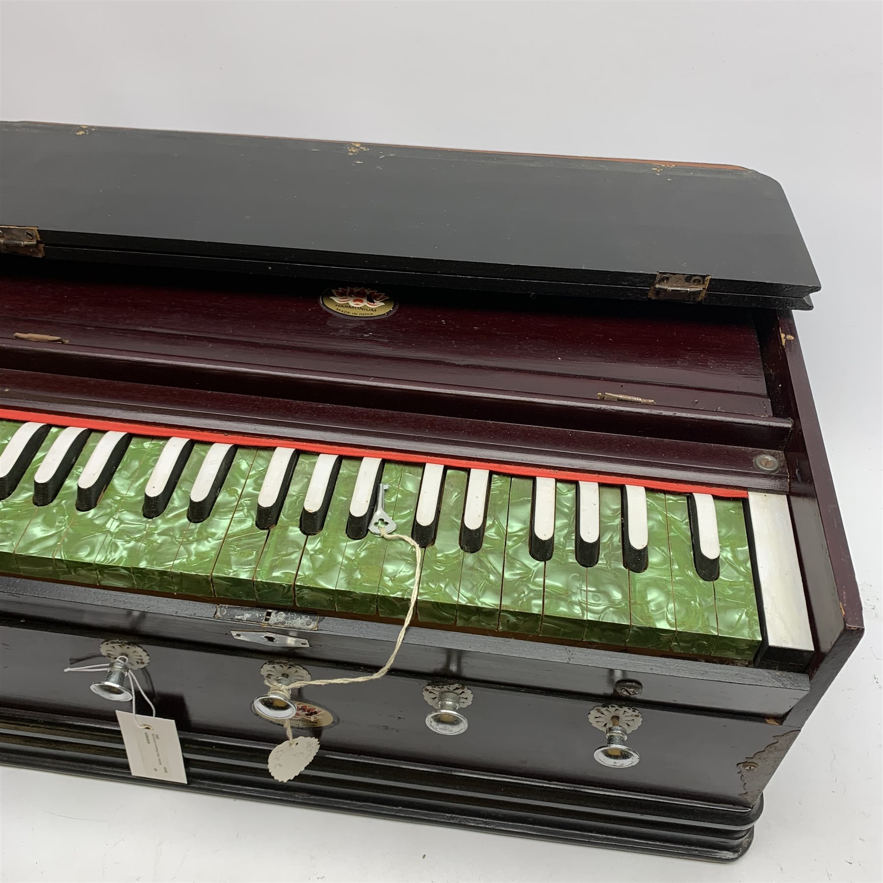 Indian portable harmonium by Kamala with mahogany stained wooden case and green pearline keys L56cm