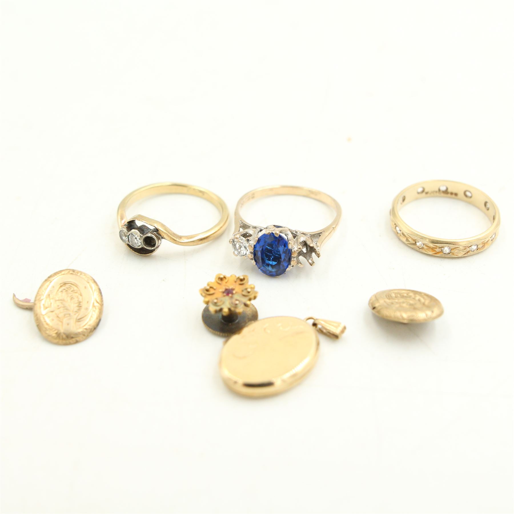 9ct gold three stone blue and white spinel ring (one stone deficient), a 9ct gold white spinel eternity ring (one stone deficient) and an 18ct gold diamond ring (one stone deficient), together with a 9ct gold oval locket pendant, a single cufflink (a/f) and a 9ct gold dress stud 