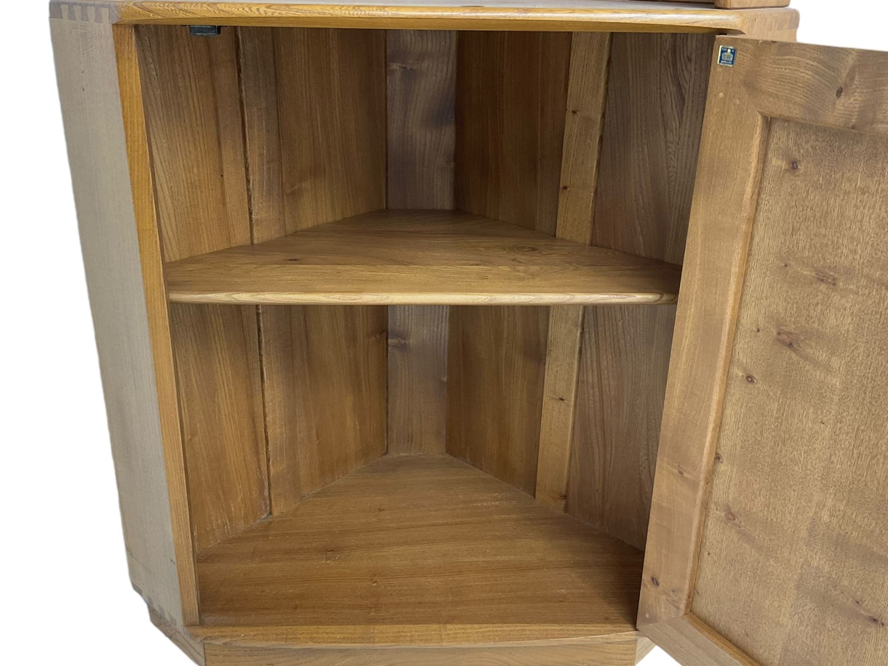 Ercol - mid-20th century '743C'  light elm corner cabinet, fitted with two open shelves over a single cupboard