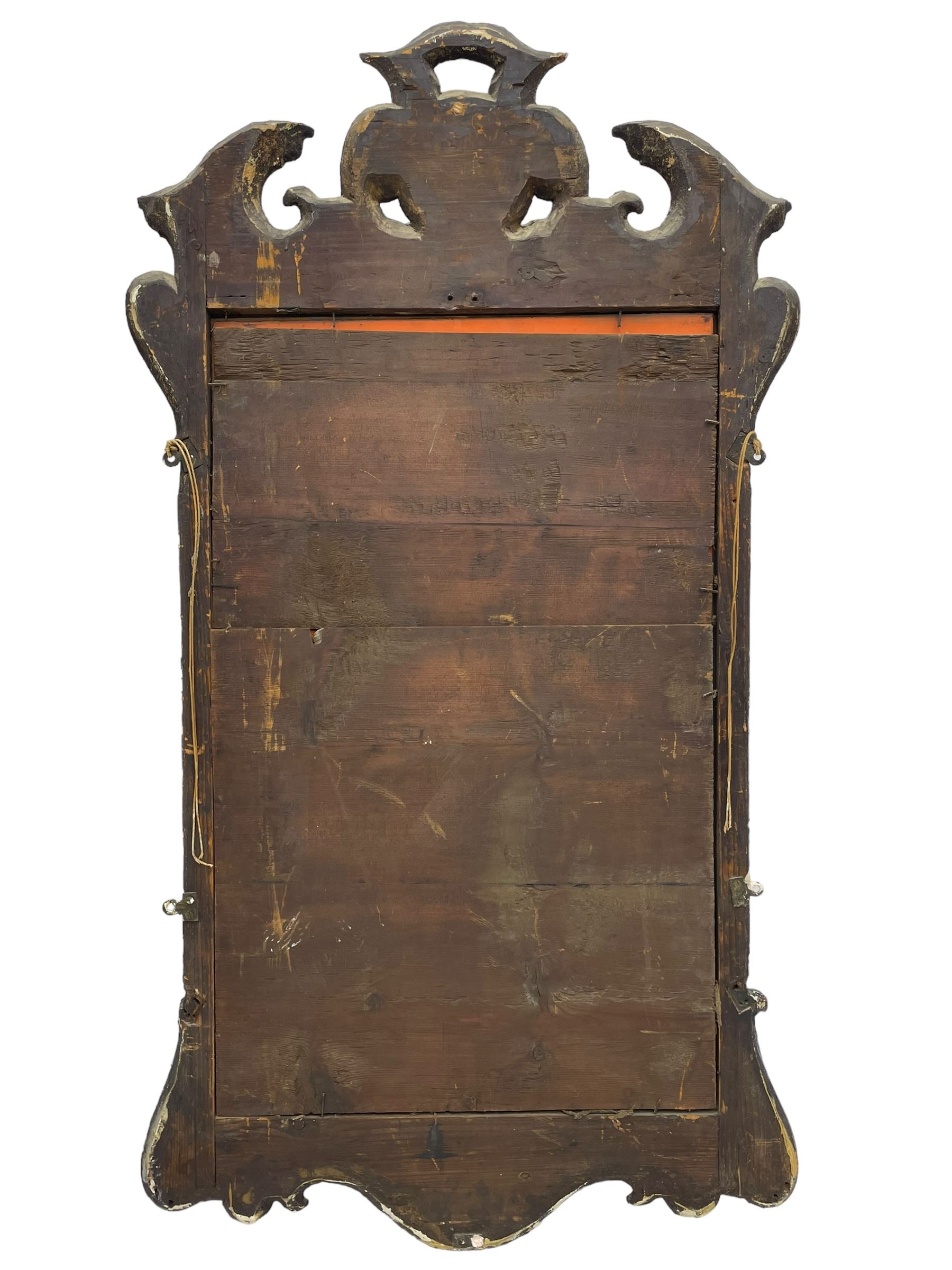 18th century black lacquered and gilt wall mirror, broken arch pediment with central cartouche decorated with curled leaves and foliate motifs, scrolled acanthus leaf eared brackets, bevelled mirror plate within gilt slip and moulded outer frame, lower shell motif surrounded by curled acanthus leaves and shield motifs 