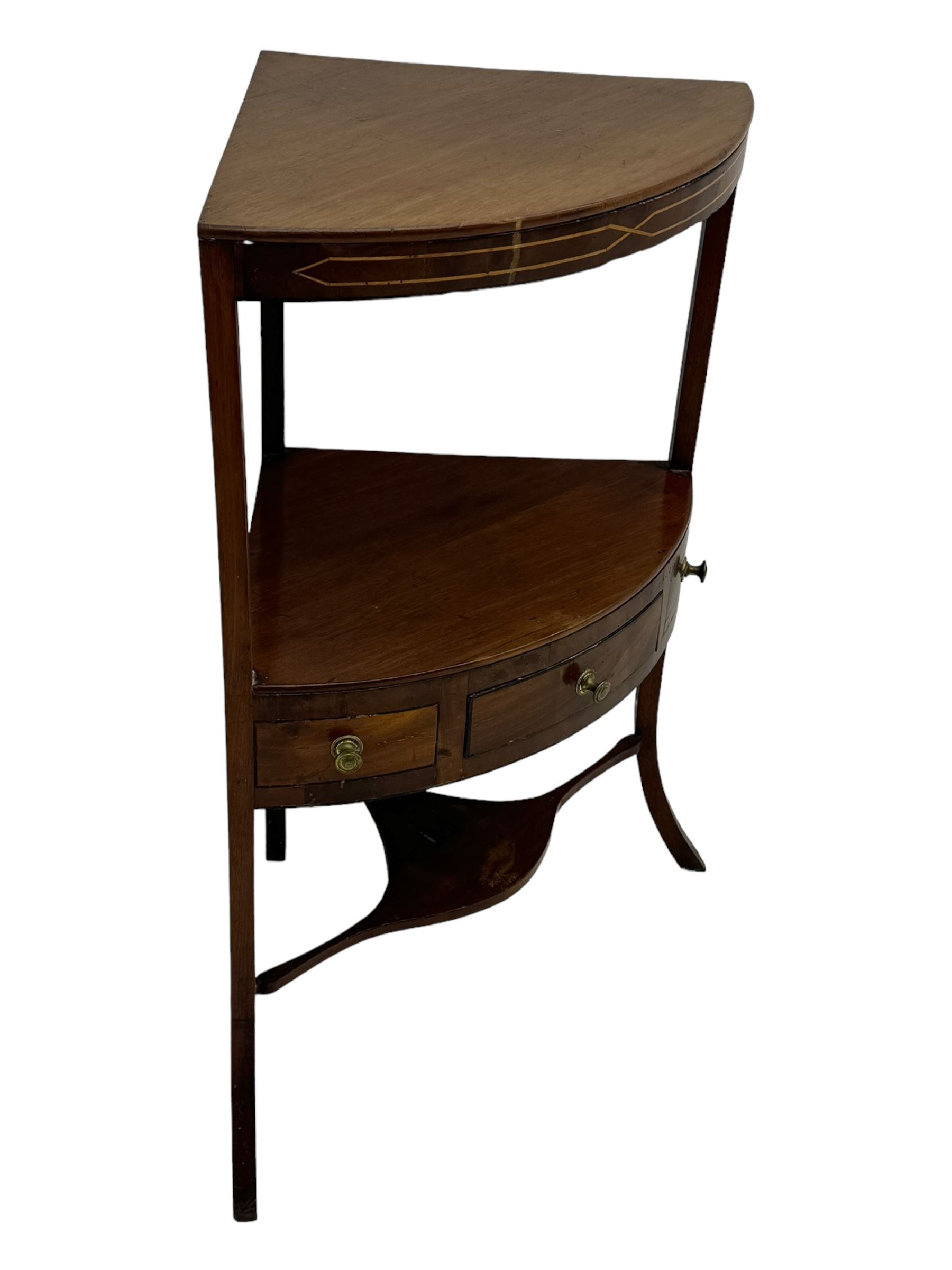 George III mahogany two-tier corner washstand, the inlaid top with geometric border, central drawer flanked by two faux drawers each with brass pull handle, on splayed supports united by shaped under-tier