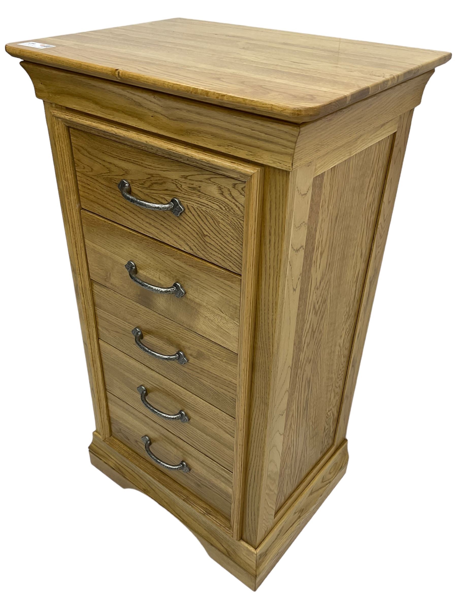 Contemporary light oak pedestal chest, moulded cornice and chamfered rectangular top with rounded fronts, over five drawers with metal handles and cock-beaded surrounds, on bracketed plinth base