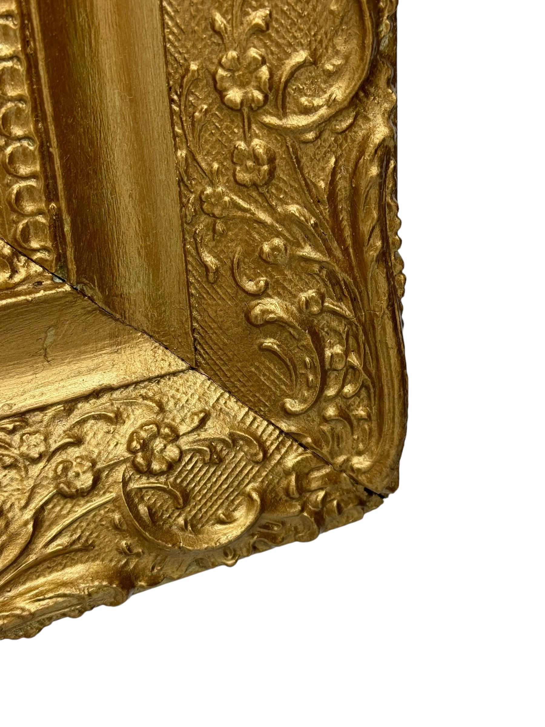 Rectangular wall mirror, in ornate gilt frame decorated with trailing leafy branches and flower heads 