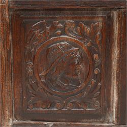 18th century carved oak coffer or chest, sloped hinged lid over panelled front, carved with three Northern European portraits with foliage surrounds decorated with birds, fitted with wrought metal carrying handles, on fluted stile supports 