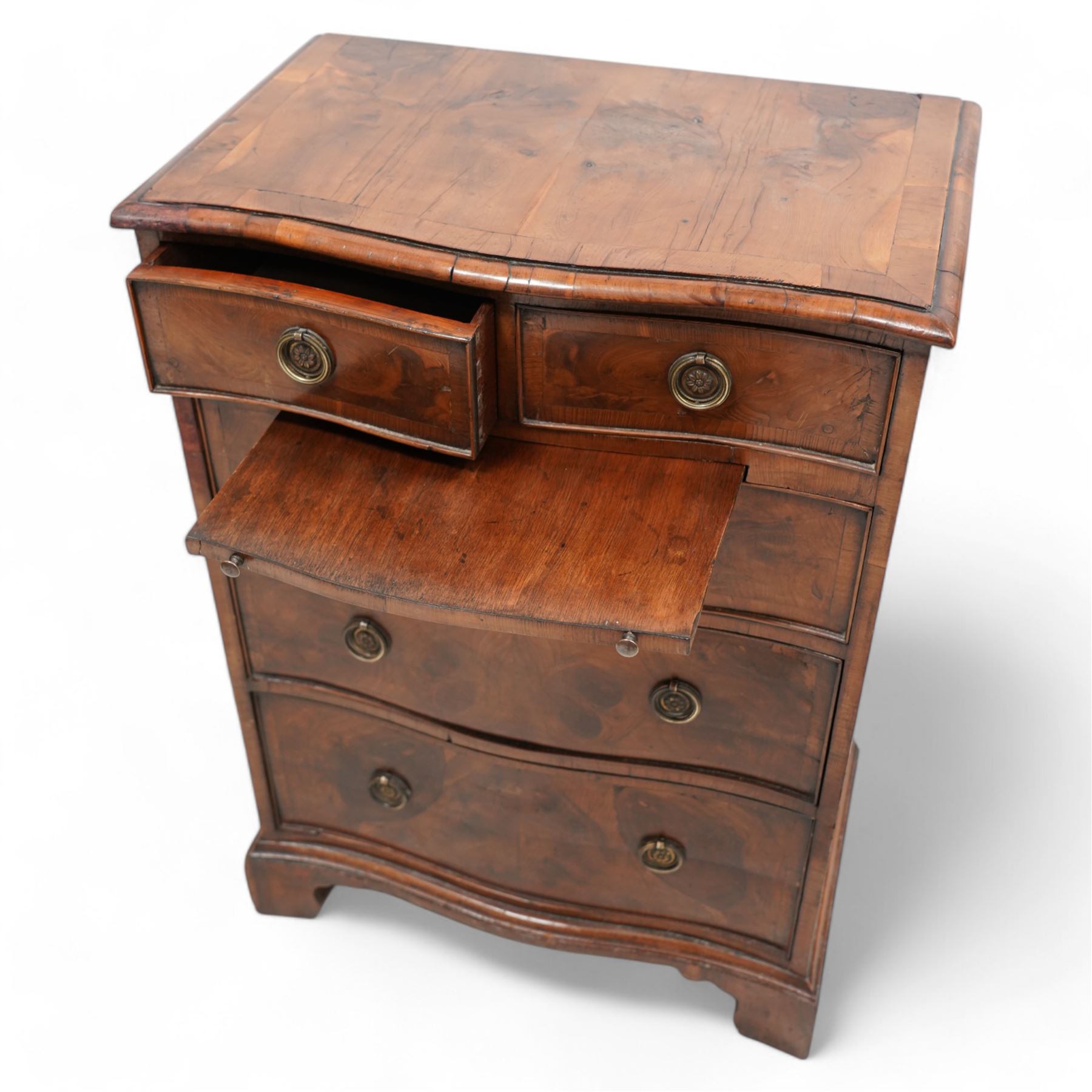 Georgian design yew wood serpentine chest, moulded and crossbanded top over two short and three long graduating cock-beaded drawers, circular pressed brass handle plates with hoop handles, fitted with slide, on bracket feet