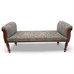 19th century mahogany framed bay window seat of tapered form, rolled arms decorated with carved scrolling, seat and arms upholstered in indigo ground floral patterned fabric, moulded lower rail over turned supports