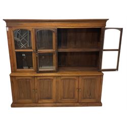 Mid-to-late 20th century Burmese teak wall cabinet, four glazed doors over four panelled doors, on moulded plinth base 