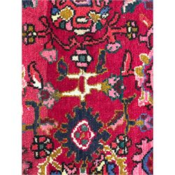 Persian Nanaj crimson ground carpet, the busy field filled with interconnecting stylised plant motifs with scrolling branches, the guarded indigo border decorated with repeating palmettes and foliate patterns