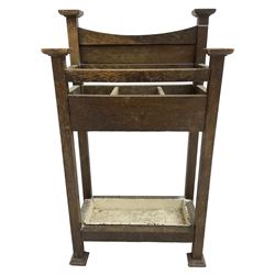 Early 20th century Arts & Crafts oak stick stand, panelled back over three divisions, fitted with metal drip tray, on square supports