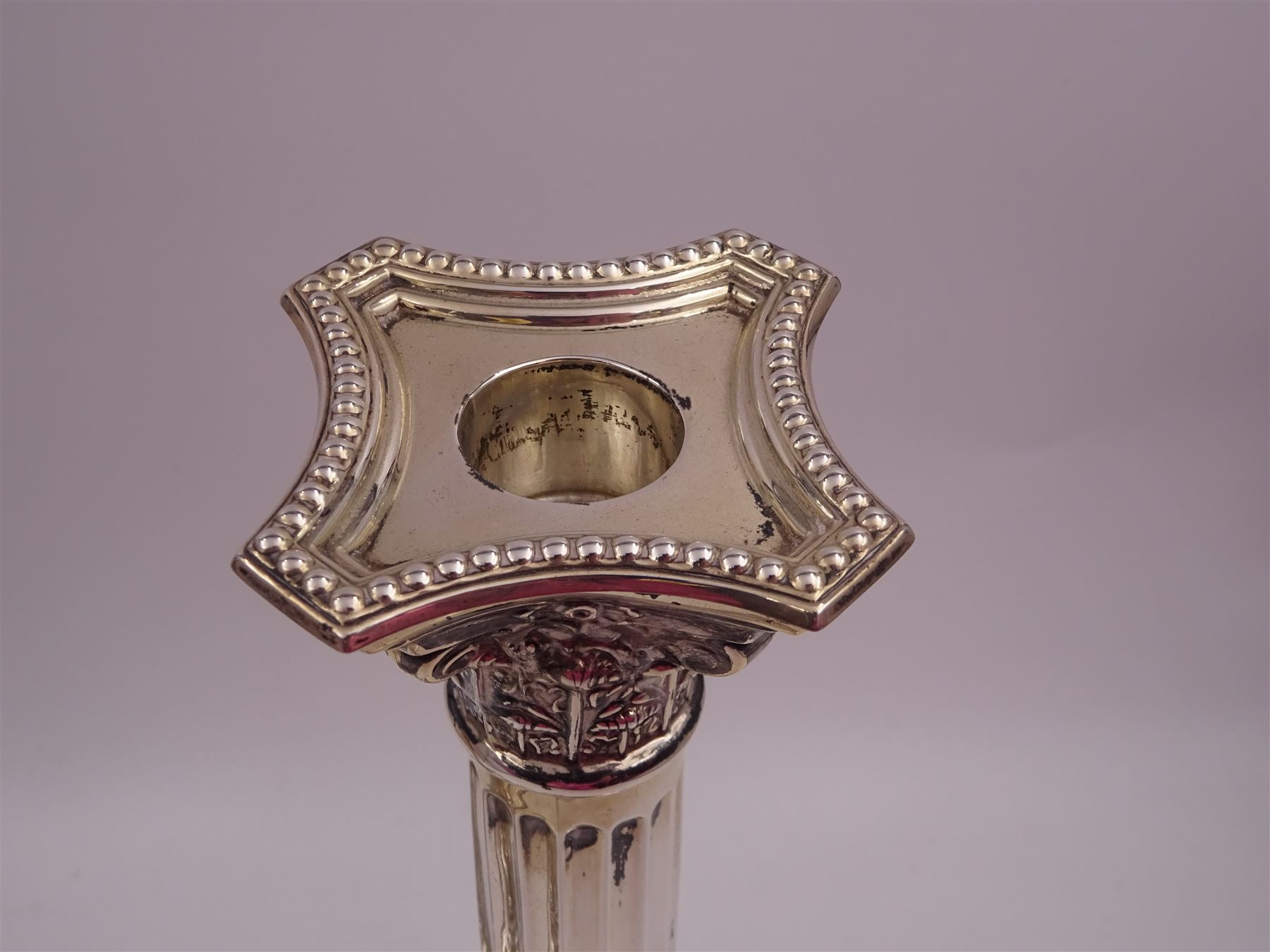 Pair of modern silver Corinthian column candlesticks, each with removable sconces with dart edging and embossed detailing, with personal engraving in a Semitic language, upon weighted stepped square bases, hallmarked Birmingham 1962, maker's marks HYC, H30.5cm