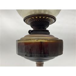 Victorian oil lamp, the faceted reservoir upon embossed copper stem and stepped circular ceramic base, with etched floral glass shade