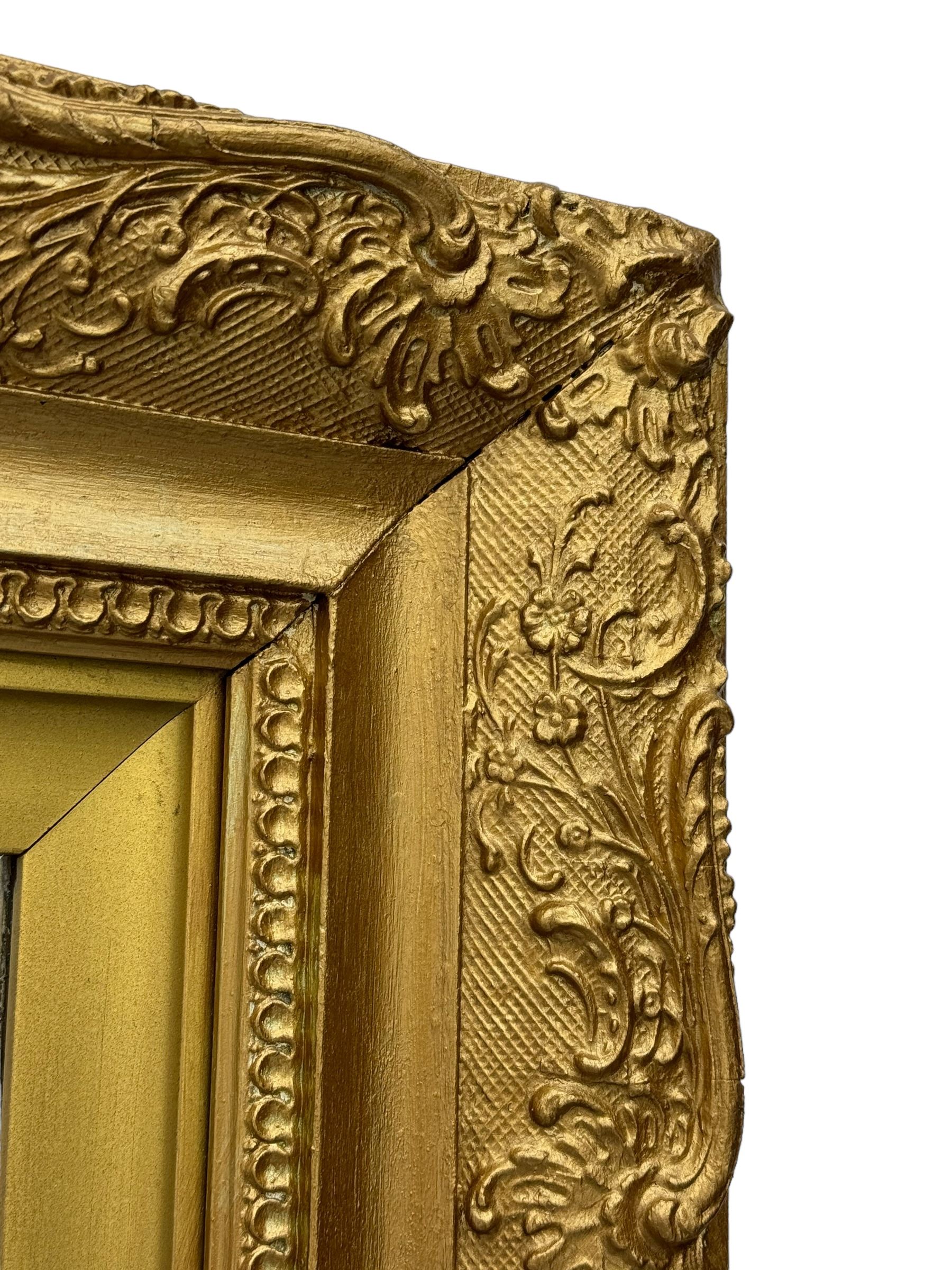 Rectangular wall mirror, in ornate gilt frame decorated with trailing leafy branches and flower heads 