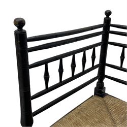 In the manner of William Morris - Arts & Crafts period corner chair, swell turned horizontal rails with balustrade back, rush seat on ring turned supports, black paint finish 