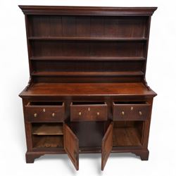 Late 18th century oak dresser, moulded cornice over three-tier plate rack, the base fitted with three drawers and two cupboards, enclosed by two panelled doors, on bracket feet, bone lozenge escutcheons 