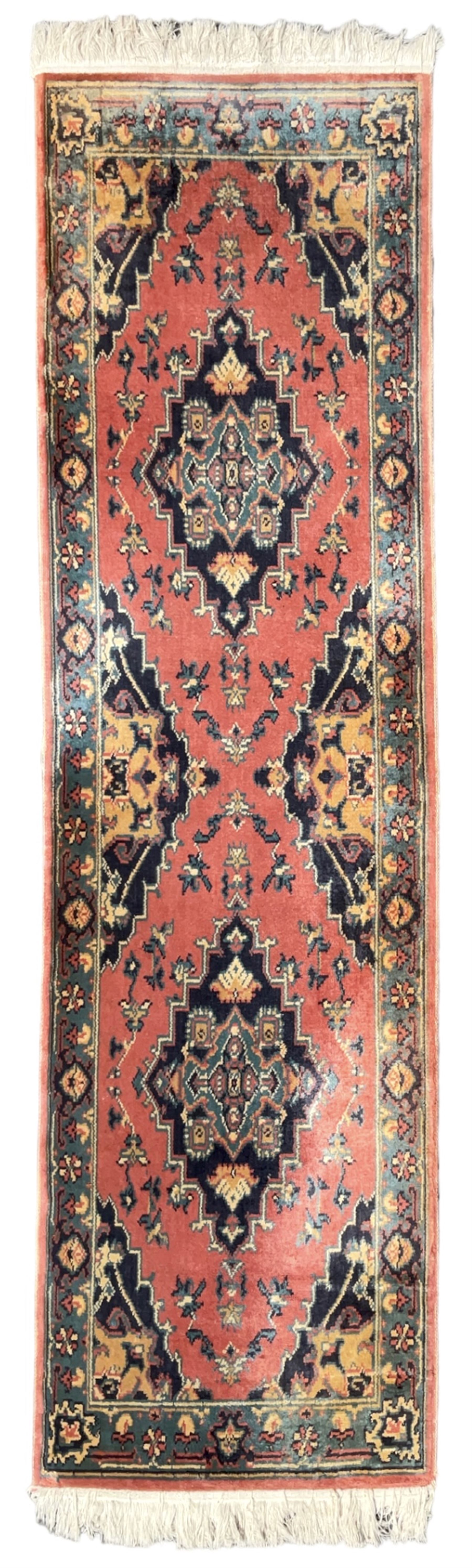 Northwest Persian salmon ground runner, the field decorated with a series of geometric medallions, surrounded by a multi-band border with floral motifs