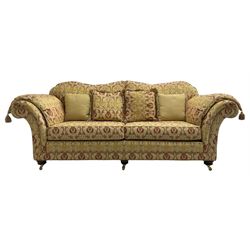 Steed Upholstery Ltd. - 'Lincoln' three-seat sofa upholstered in gold 'Olympia' floral pattern corded and tasselled fabric, together with scatter cushions and arm covers, on turned feet with brass castors