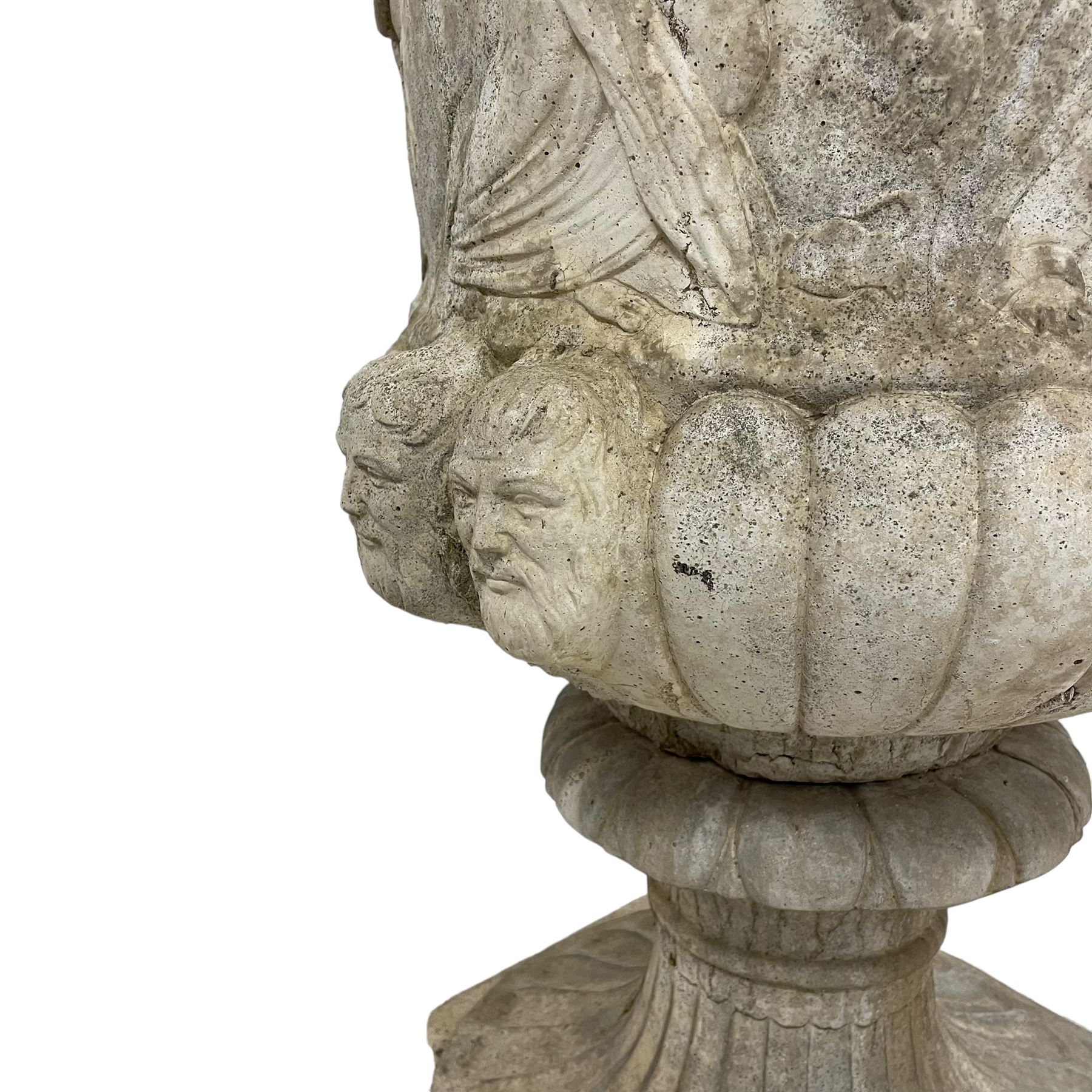 Cast stone Campana shaped urn, decorated with festival scenes over gadrooned underbelly, circular foot on square base