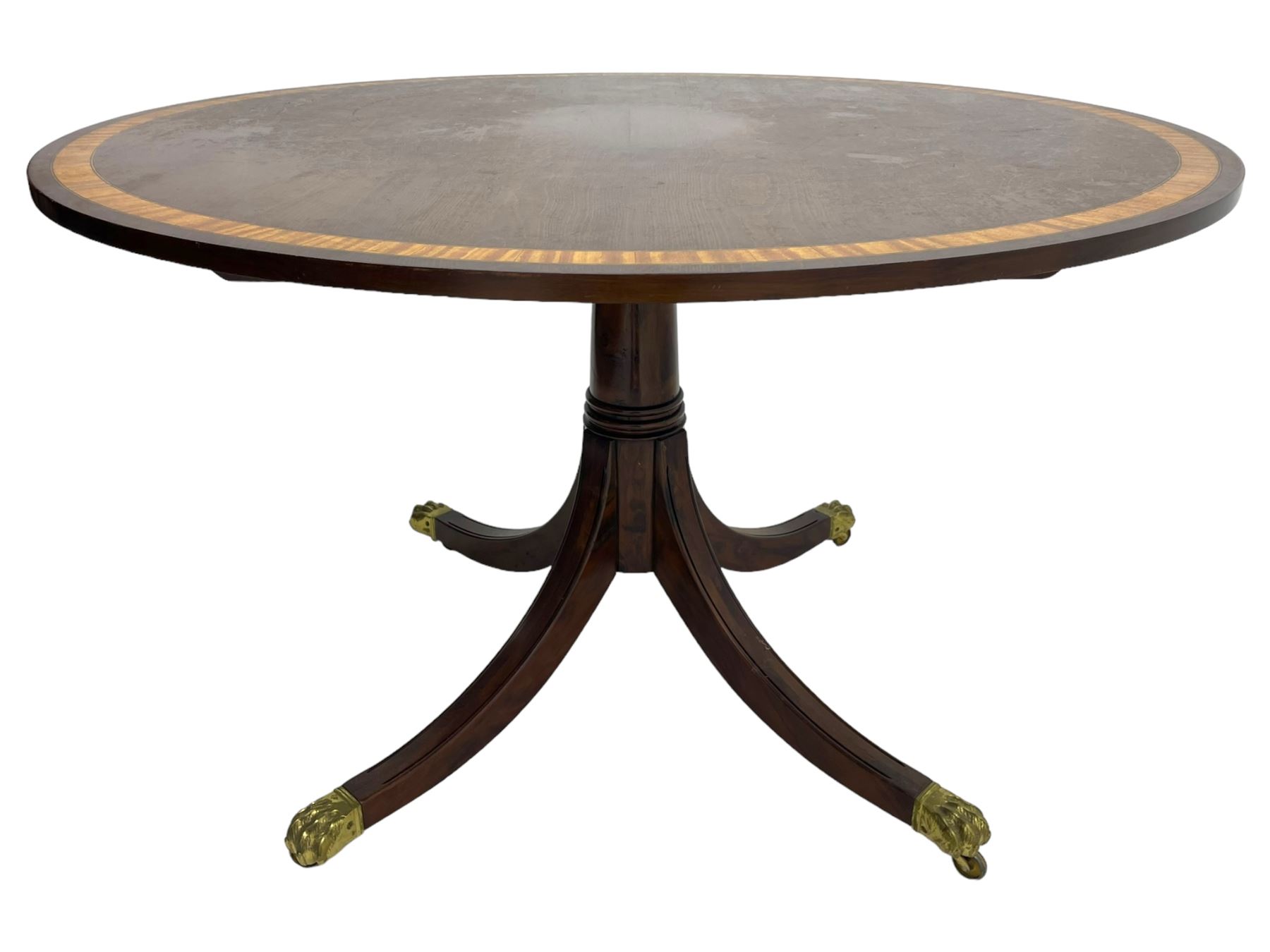 Georgian design inlaid chestnut wood centre table, the circular tilt-top inlaid with satinwood banding, gun barrel turned pedestal on four out-splayed supports, cast brass hairy paw castors, stamped 'P.H.R & Co. Holt, England' 