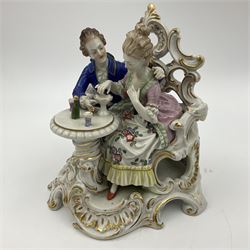 Figure group, probably Volkstedt, modelled as a courting couple seated before a table, the ornate bench and table conforming with and leading from the gilt heightened scrolling base, with blue painted mark beneath, H14.5cm
