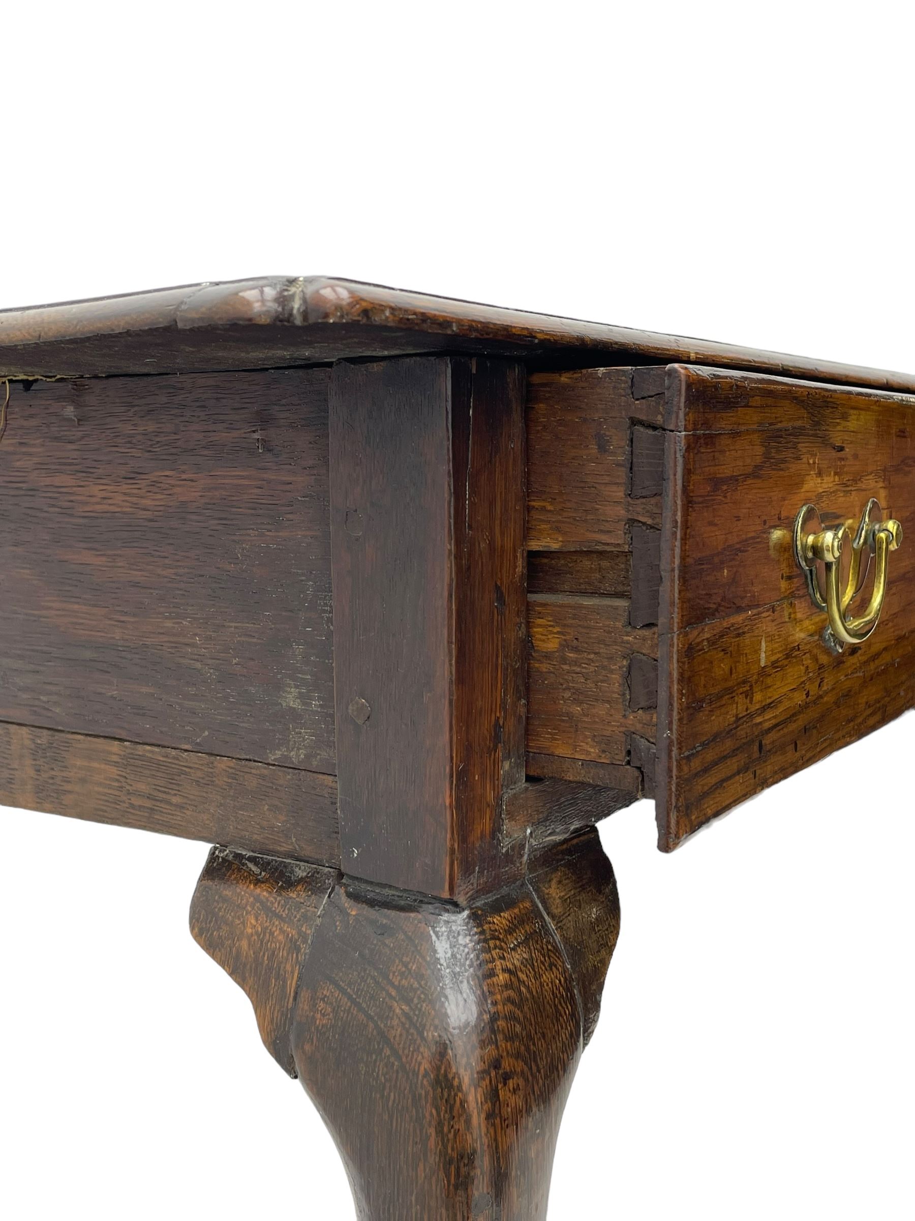 George III oak low-boy, moulded rectangular top with shaped corners, fitted with single drawer, shaped brass handle plates and escutcheon, on cabriole supports 