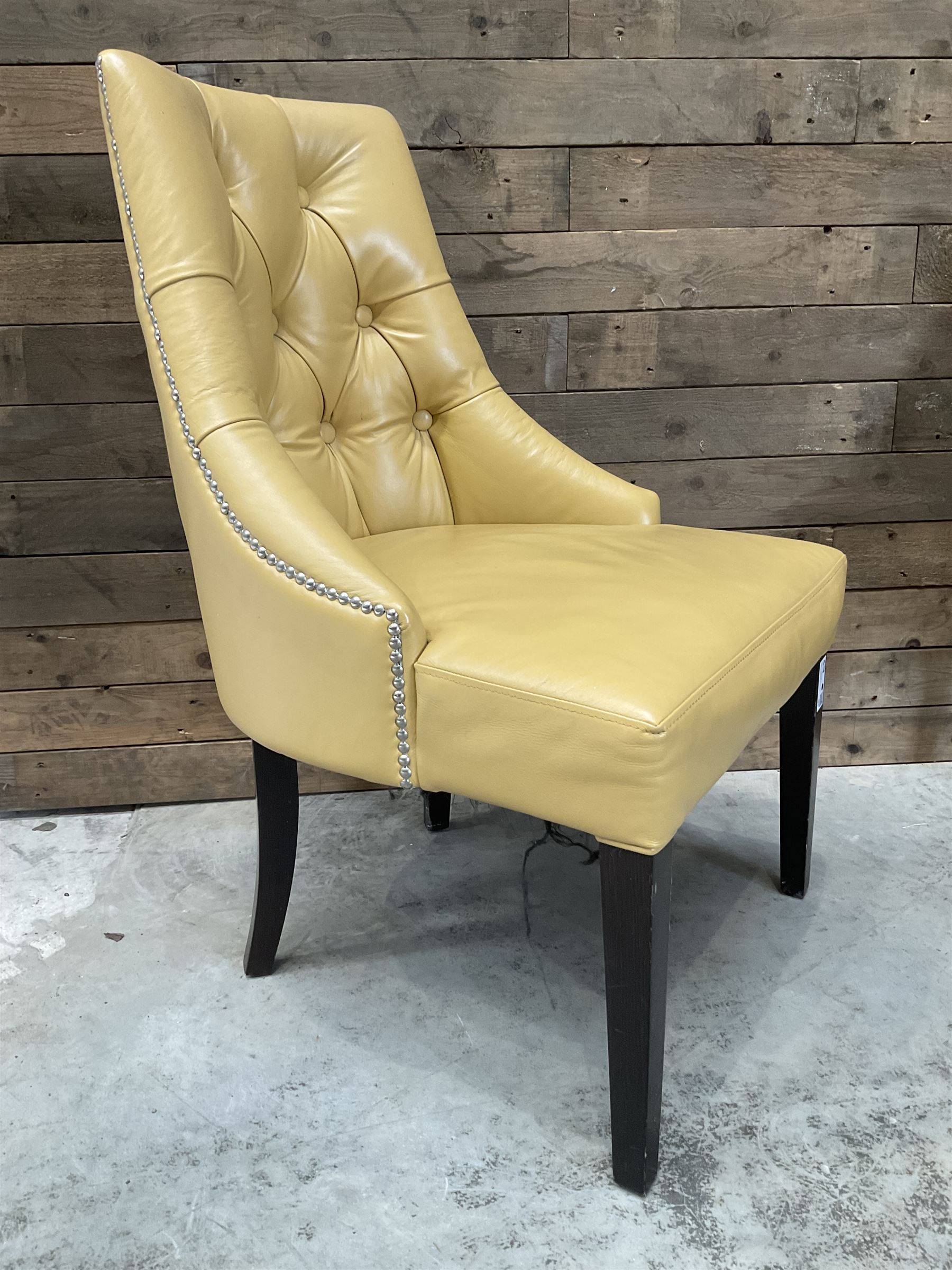 Four high back chairs upholstered in buttoned beige leather, studded detail, rosewood legs