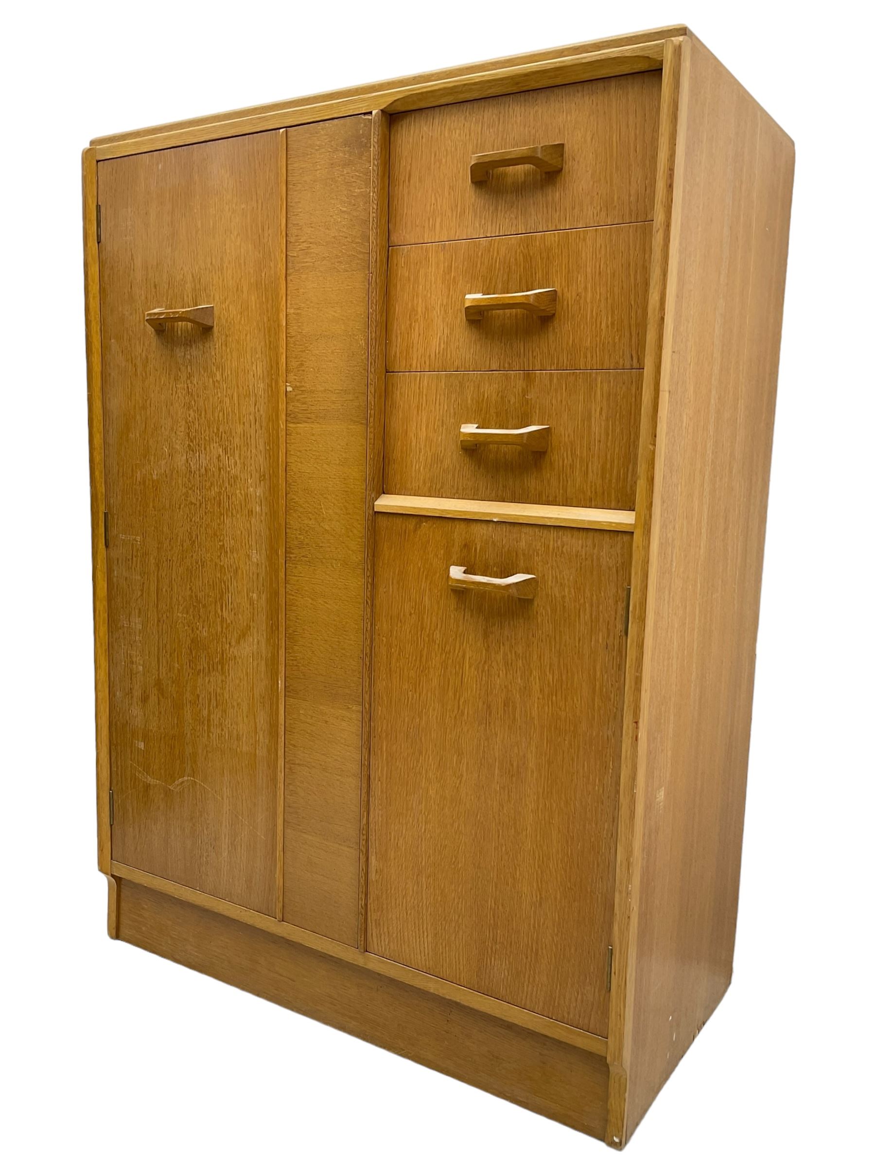 G-Plan - mid 20th century teak tallboy or combination wardrobe, left side with full-height hanging cupboard, right side with three drawers, the top fitted with vanity mirror, above cupboard with shelves, raised on a plinth base