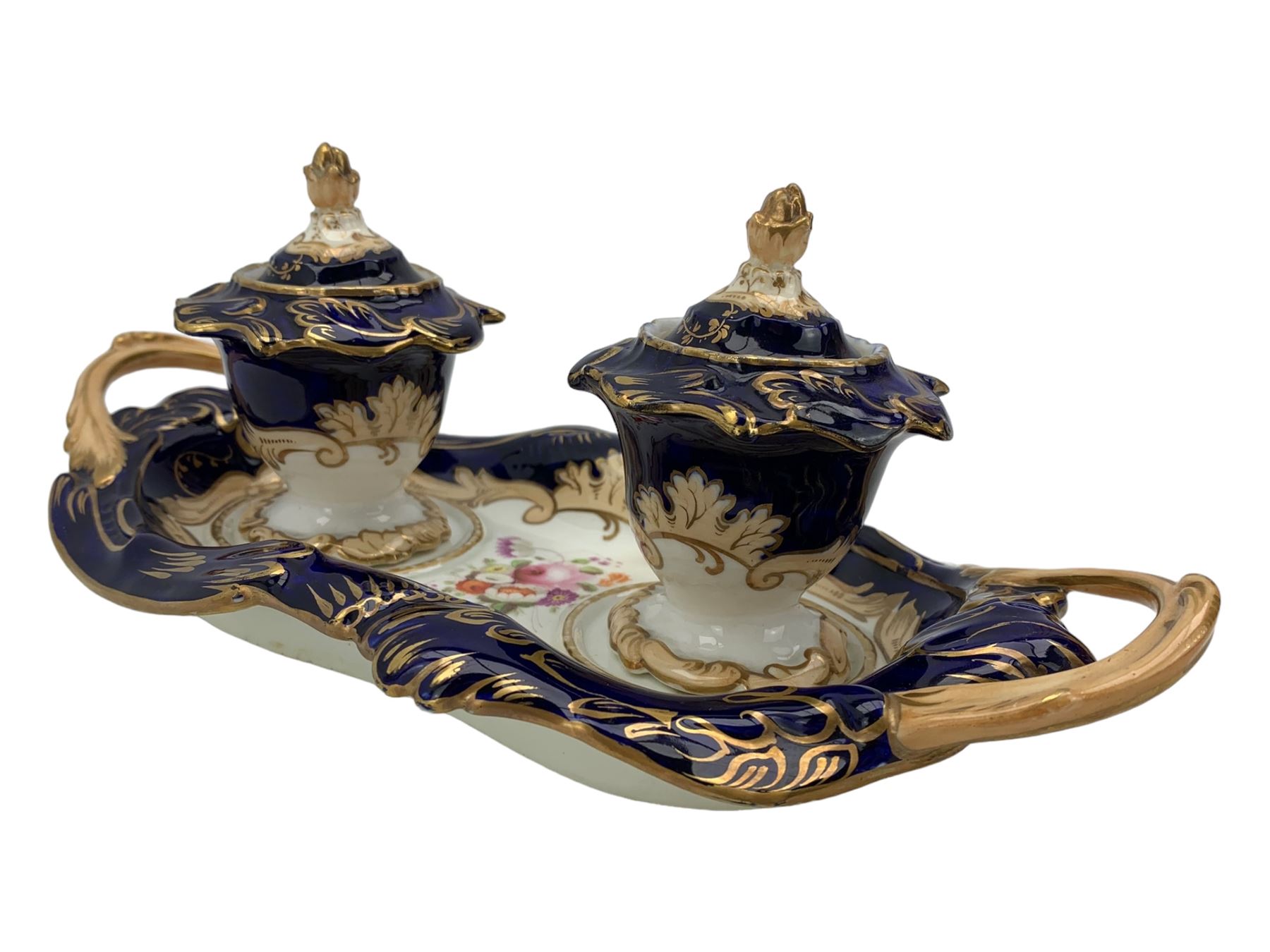 19th century porcelain inkstand, the oblong twin handled base centrally painted with a floral bouquet, flanked by two footed inkwells and covers, with rococo-inspired acanthus moulded borders and handles, pattern no. 2/3339, L26.5cm 