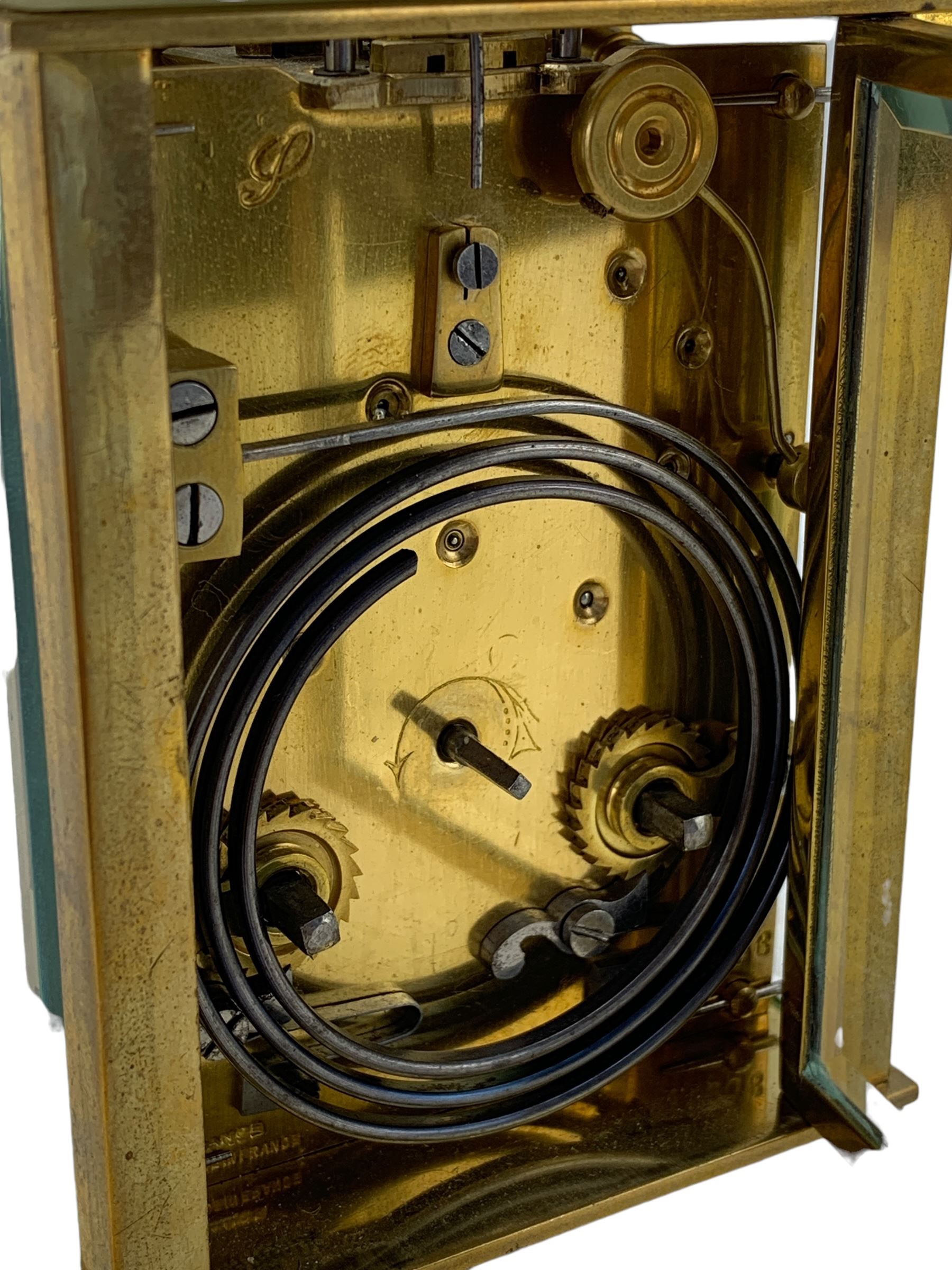 French - early 20th century two train carriage clock, in an onyx serpentine case raised on bun feet, with four bevelled panels and rectangular escapement viewing panel, white enamel dial with Roman numerals and steel spade hands, 8-day movement with a jewelled lever platform escapement and rack striking, sounding the hours and half hours on a coiled gong. With key.