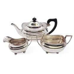 Silver three piece tea service, comprising teapot, twin handled open sucrier and a milk jug, all of oval part fluted form and upon four bun feet, the teapot with black plastic handle and finial, hallmarked S Blanckensee & Son Ltd, Chester 1930, teapot H16cm