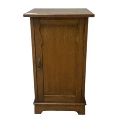 Arts and Crafts period oak pot cupboard, shaped panelled door enclosing single shelf