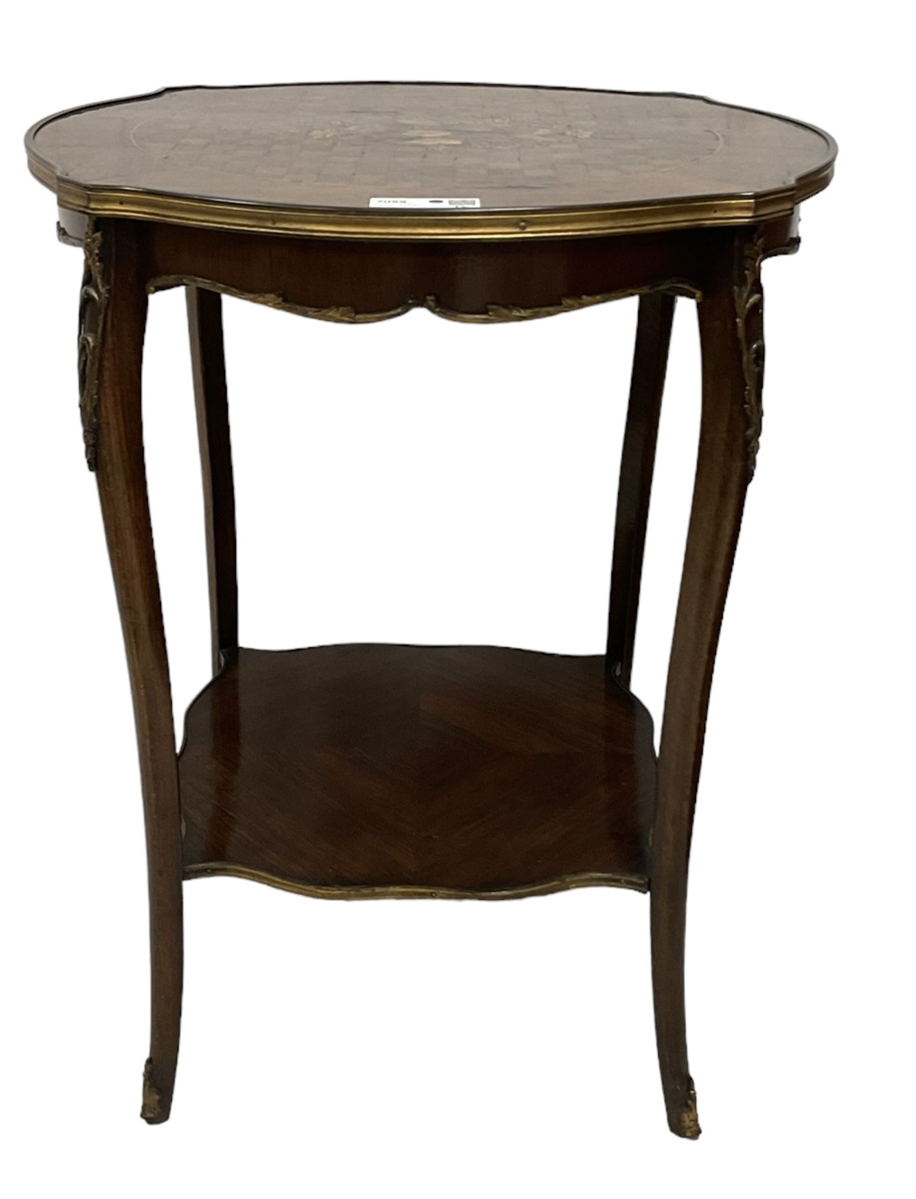 Early 20th century French two-tier marquetry inlaid walnut side table, shaped circular top with gilt metal edge, central chequered inlaid circular panel with floral motif, raised on cabriole supports with gilt metal mounts, united  by undertier