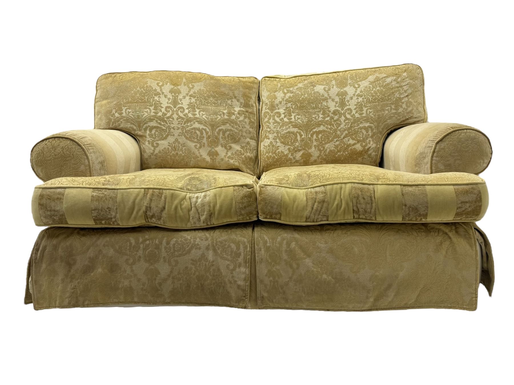 Contemporary two-seat sofa, upholstered in damask fabric with a pale gold floral pattern, rolled arms, loose back and seat cushions, on matching skirted base with concealed castors